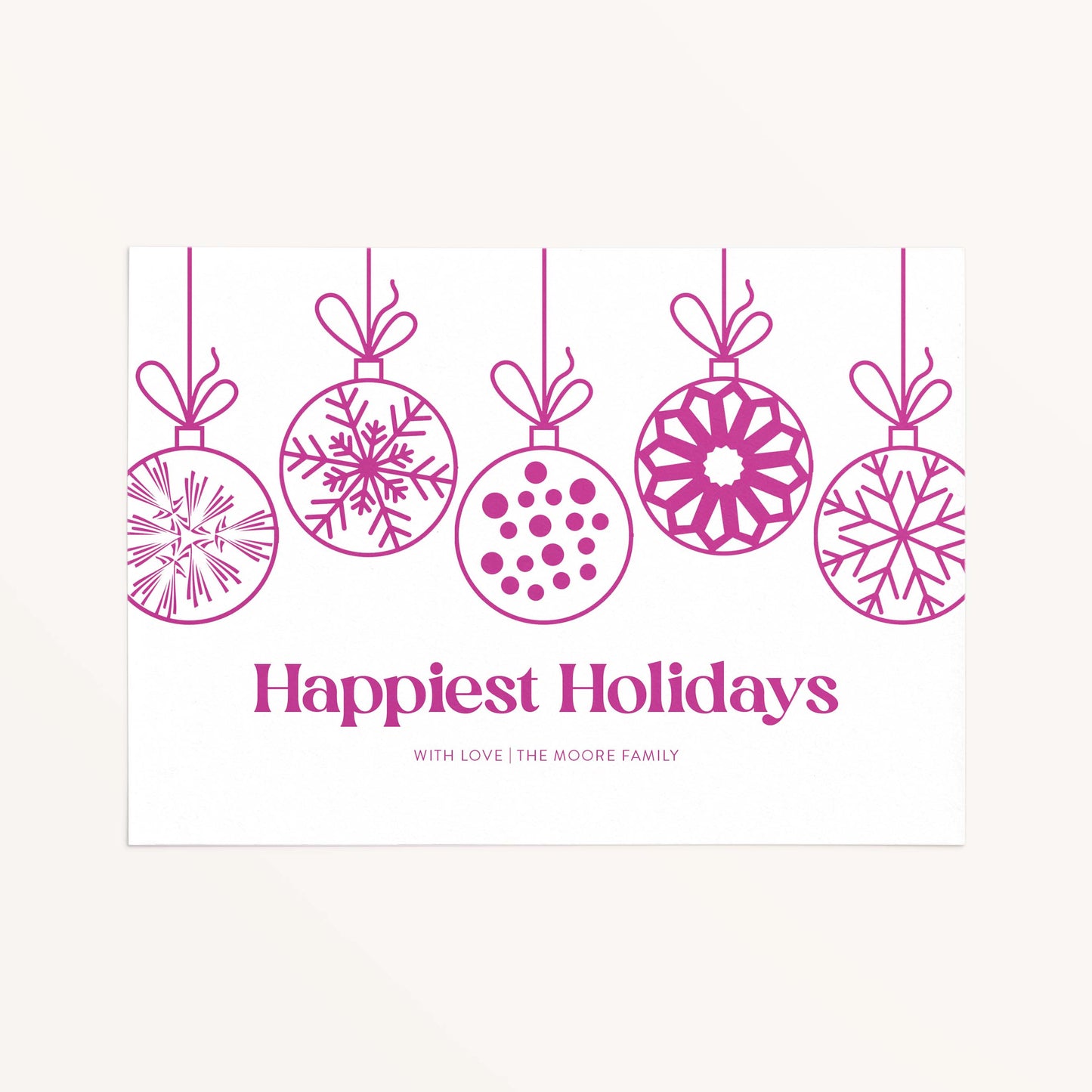 Personalized holiday card with modern hanging ornaments and Happiest Holidays message in magenta.