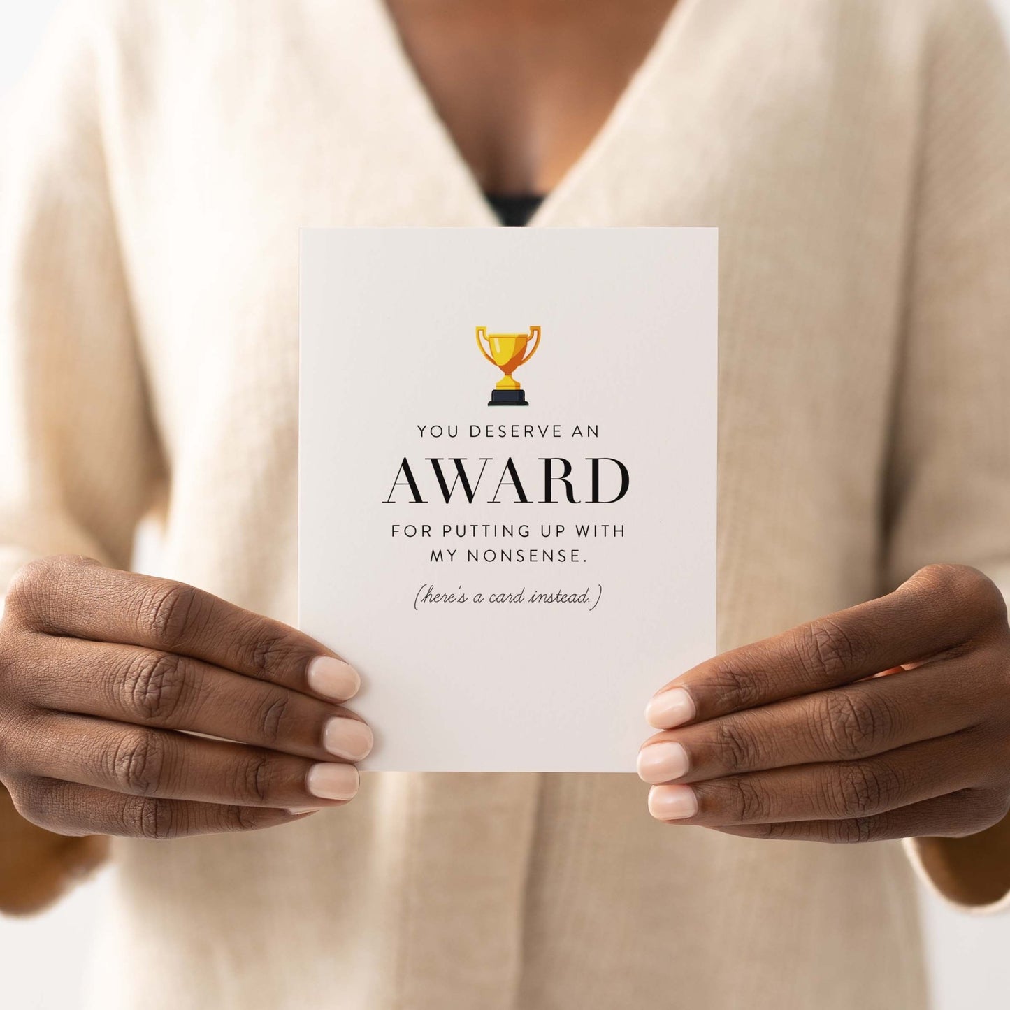 Person holding humorous award greeting card with gold trophy graphic