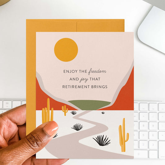 Hand holding desert landscape retirement greeting card