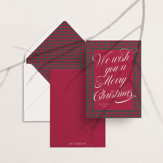 Red and green plaid custom holiday card paired with matching patterned envelope liner on white envelope and red backing.
