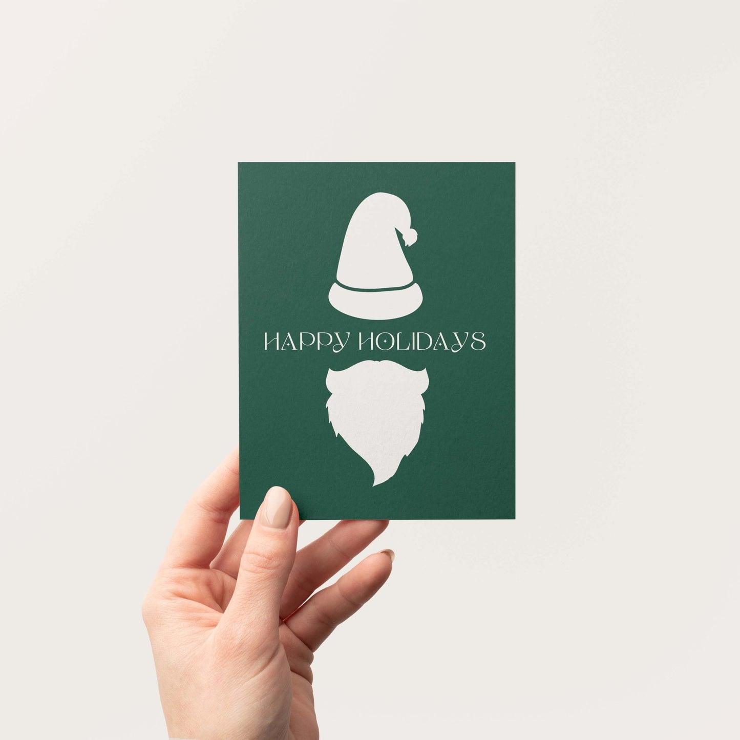 Minimalist Christmas greeting card with Santa hat and beard design held in one hand