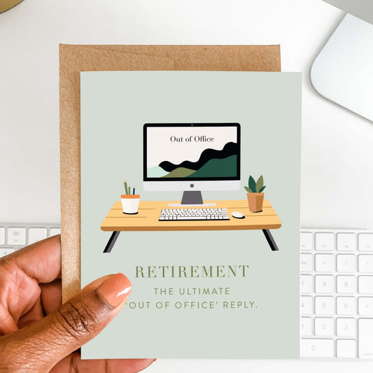 Person holding retirement greeting card with desk illustration and kraft envelope on a light workspace background.