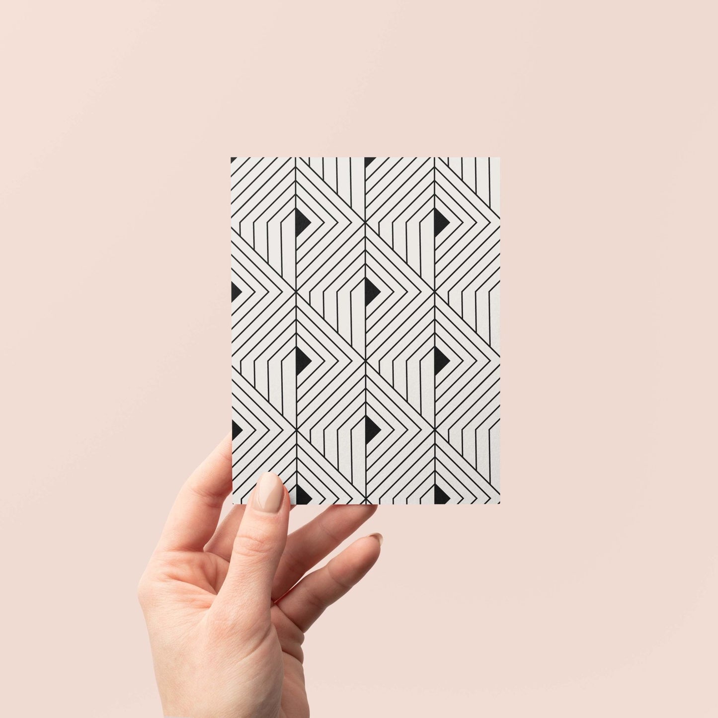 Hand holding The Prism Greeting Card by Blú Rose displaying the geometric angular pattern on a blush background