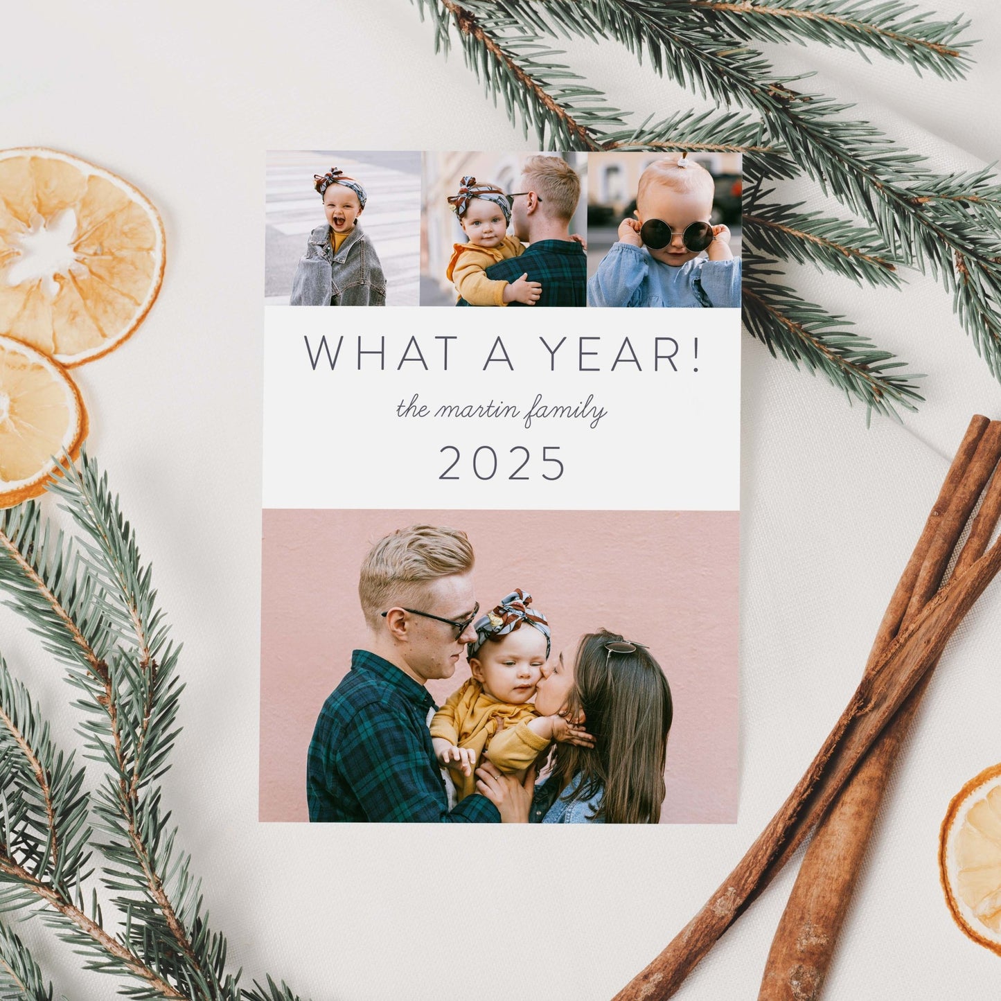 What a Year holiday card styled with pine greenery, cinnamon sticks, and dried oranges.