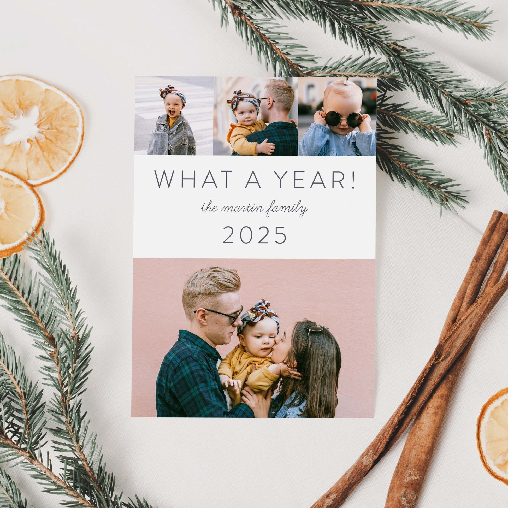 What a Year holiday card styled with pine greenery, cinnamon sticks, and dried oranges.