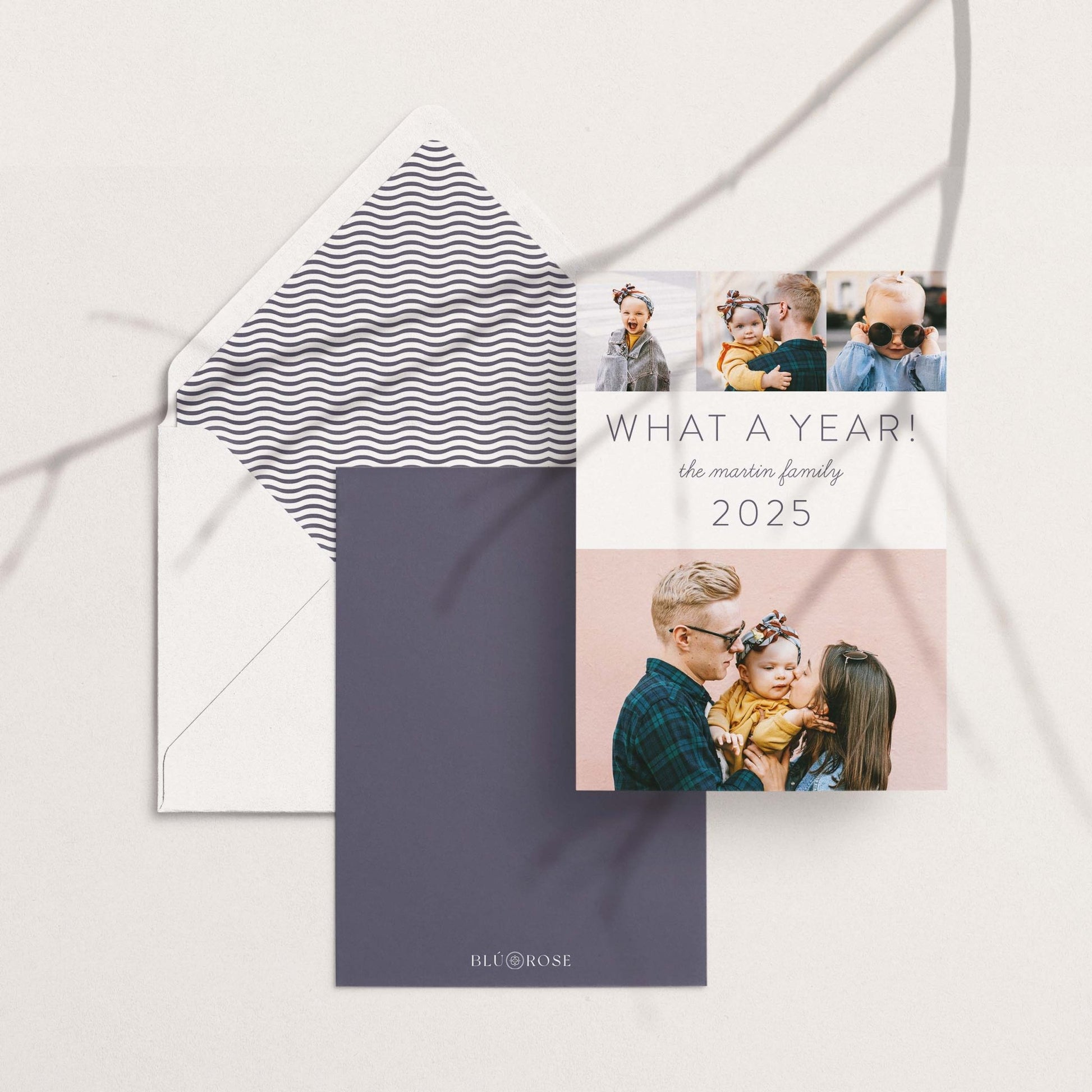 What a Year holiday card shown with matching envelopes in a modern flat lay with neutral background.
