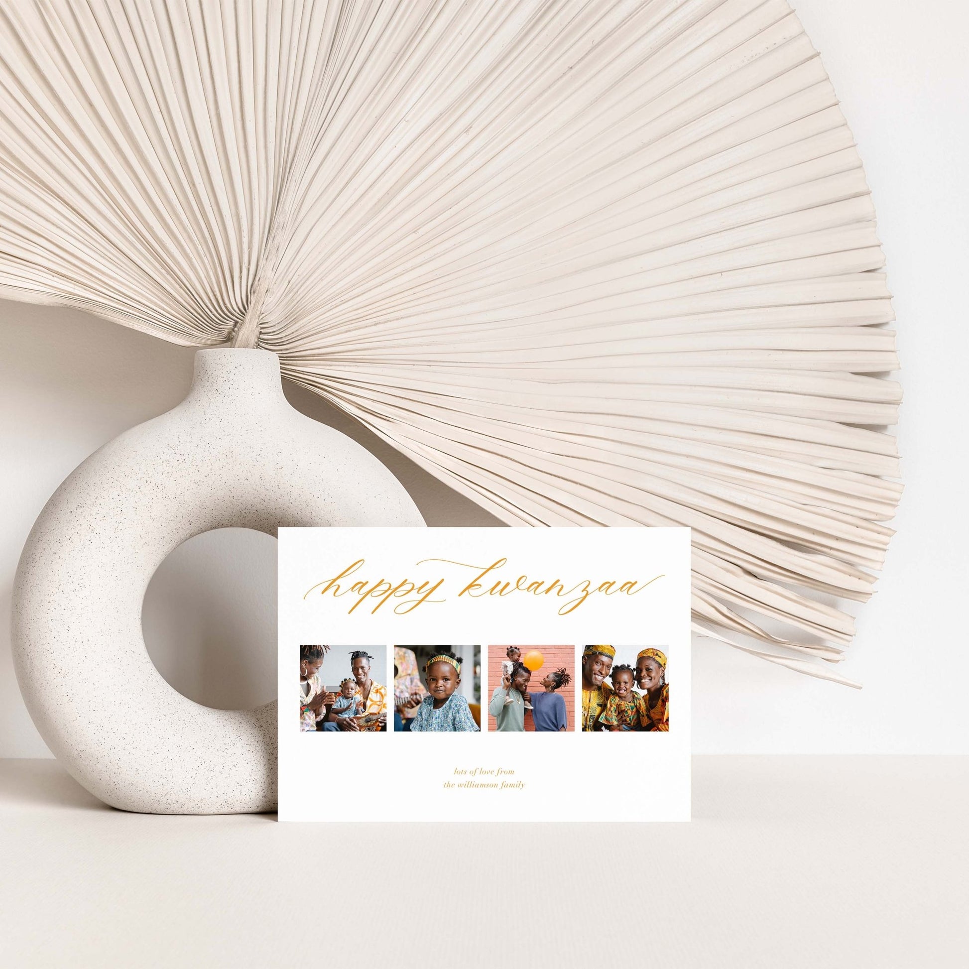 Custom Four Photo Holiday Card displayed with neutral décor and modern vase.