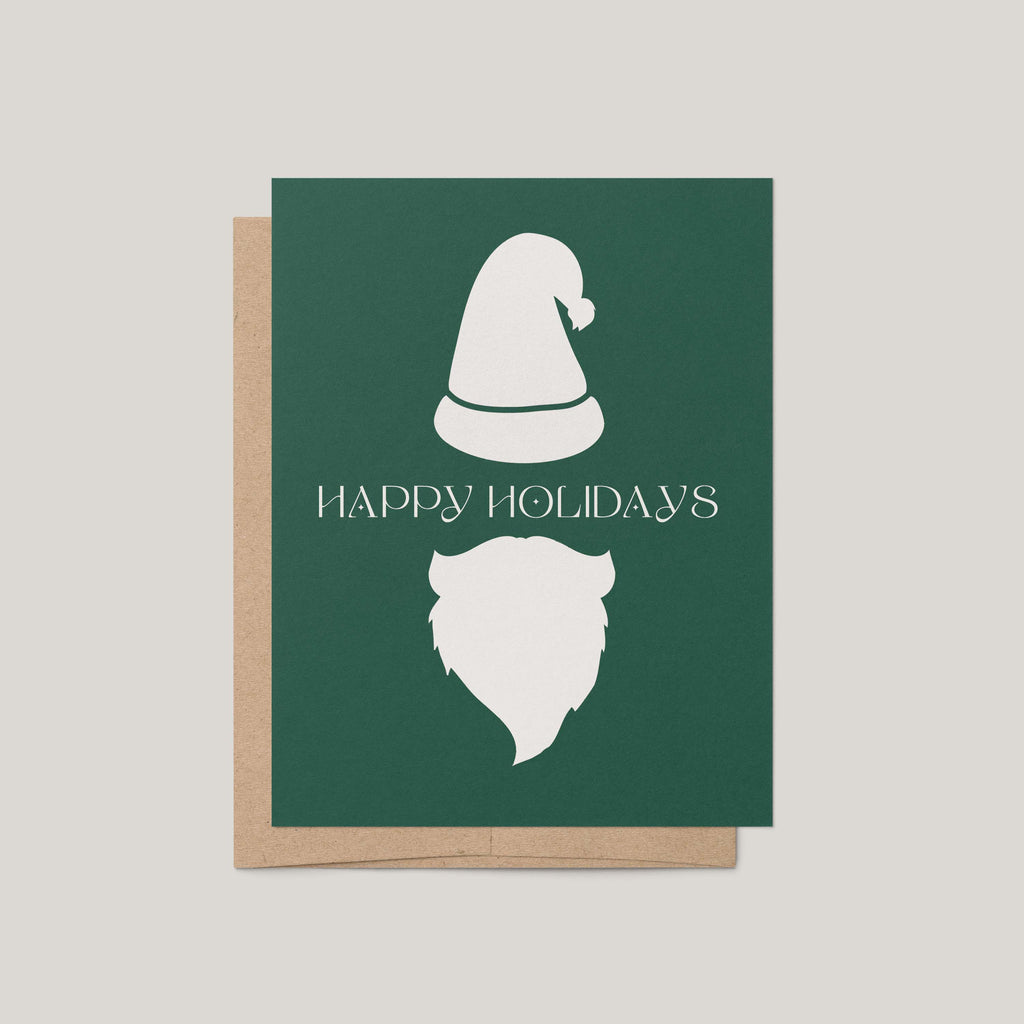 Minimalist Santa Christmas card by Blú Rose, forest green card with a white Santa hat and beard and 'Happy Holidays' message, shown with a kraft envelope