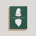 Minimalist Santa Christmas card by Blú Rose, forest green card with a white Santa hat and beard and 'Happy Holidays' message, shown with a kraft envelope