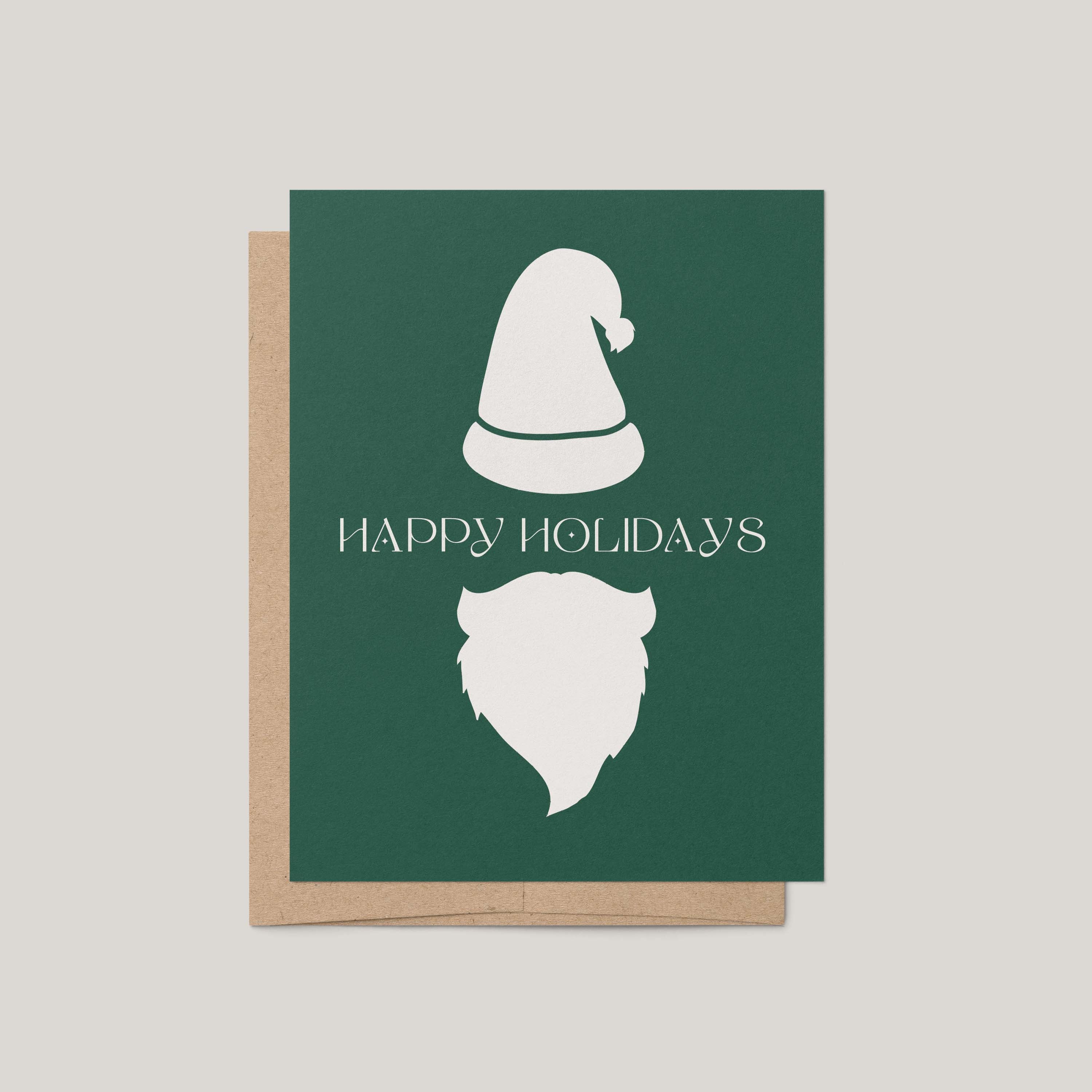 Minimalist Santa Christmas card by Blú Rose, forest green card with a white Santa hat and beard and 'Happy Holidays' message, shown with a kraft envelope