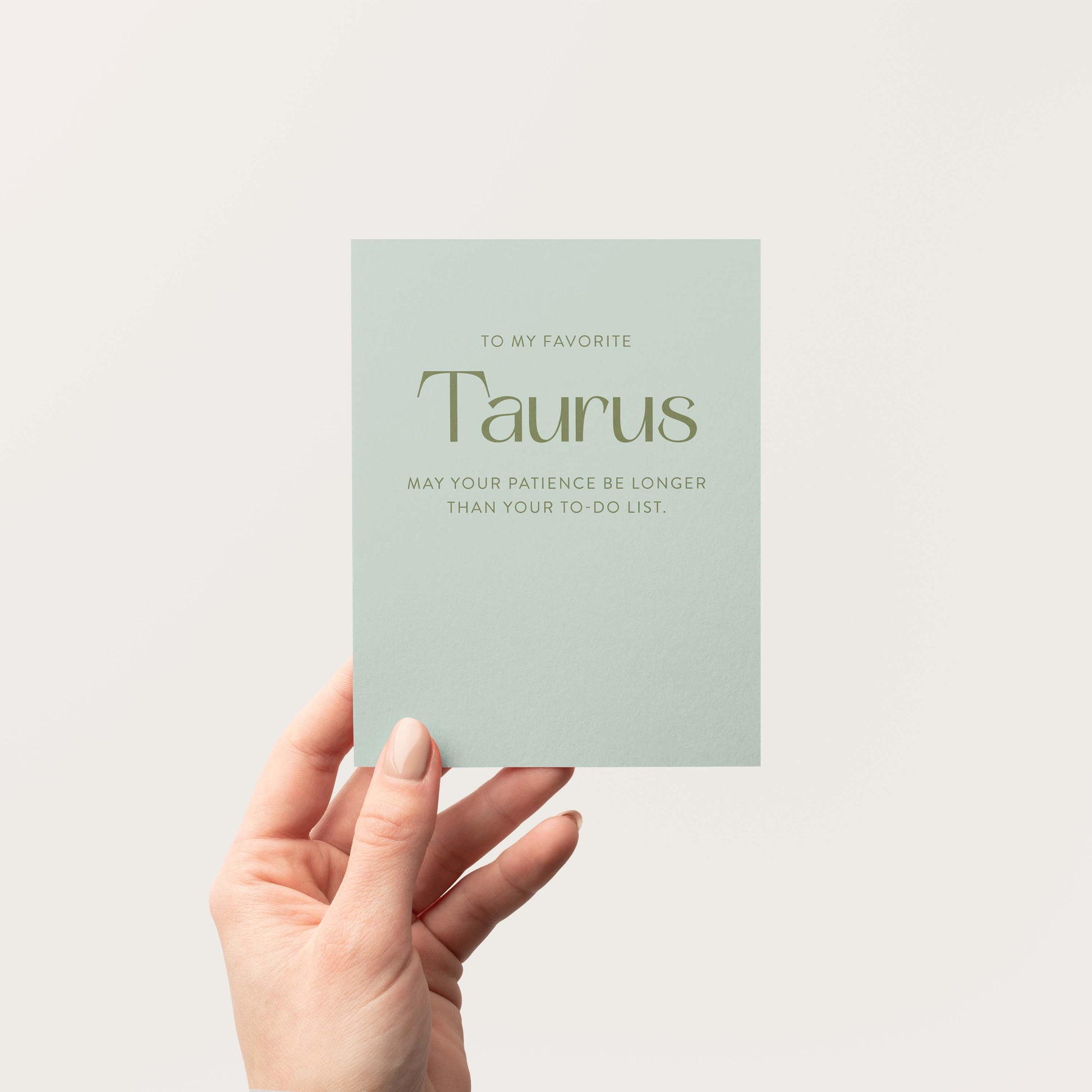 Taurus astrology card in sage green held open showing front design with birthday message