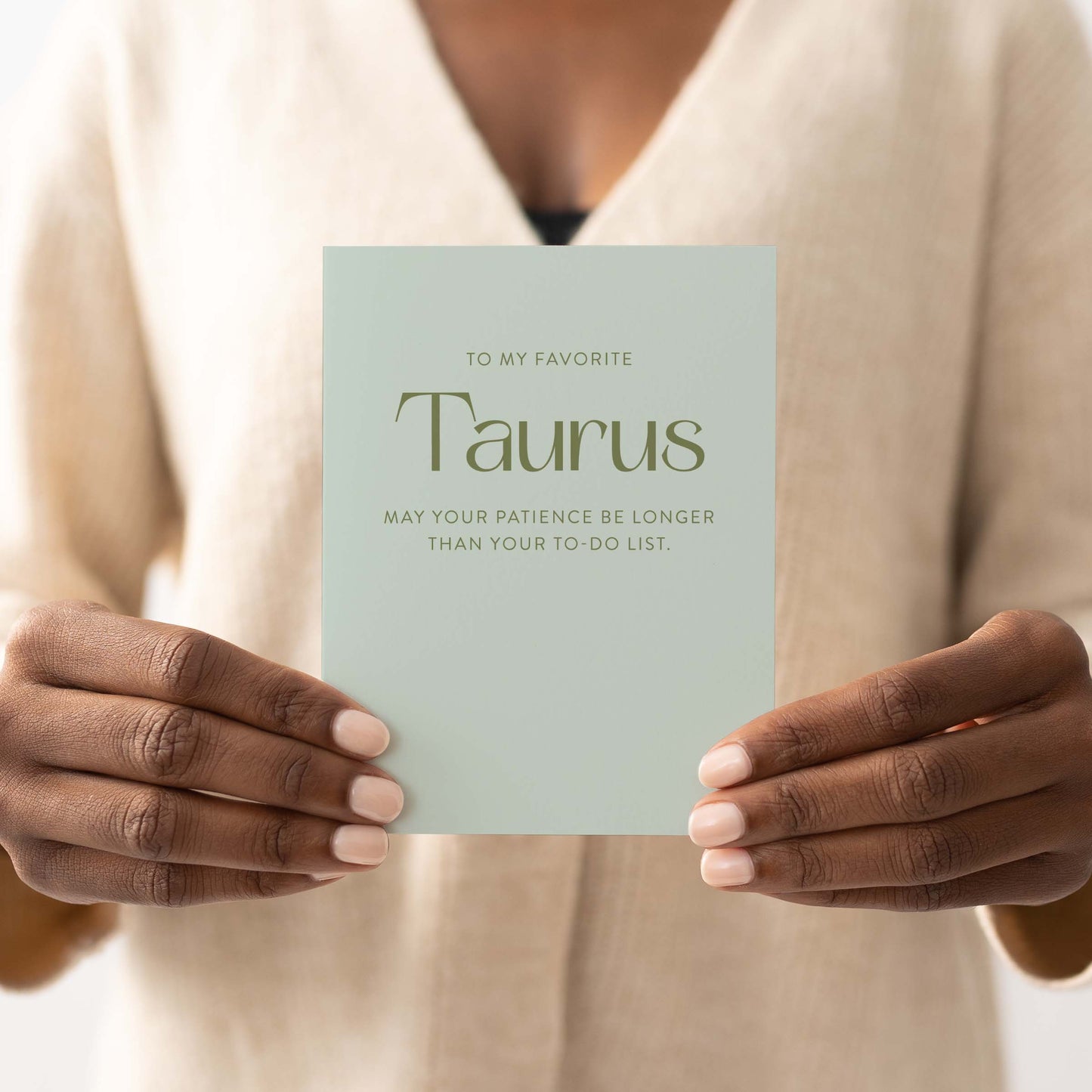 Person holding Taurus greeting card showing full front design with sage green colorway