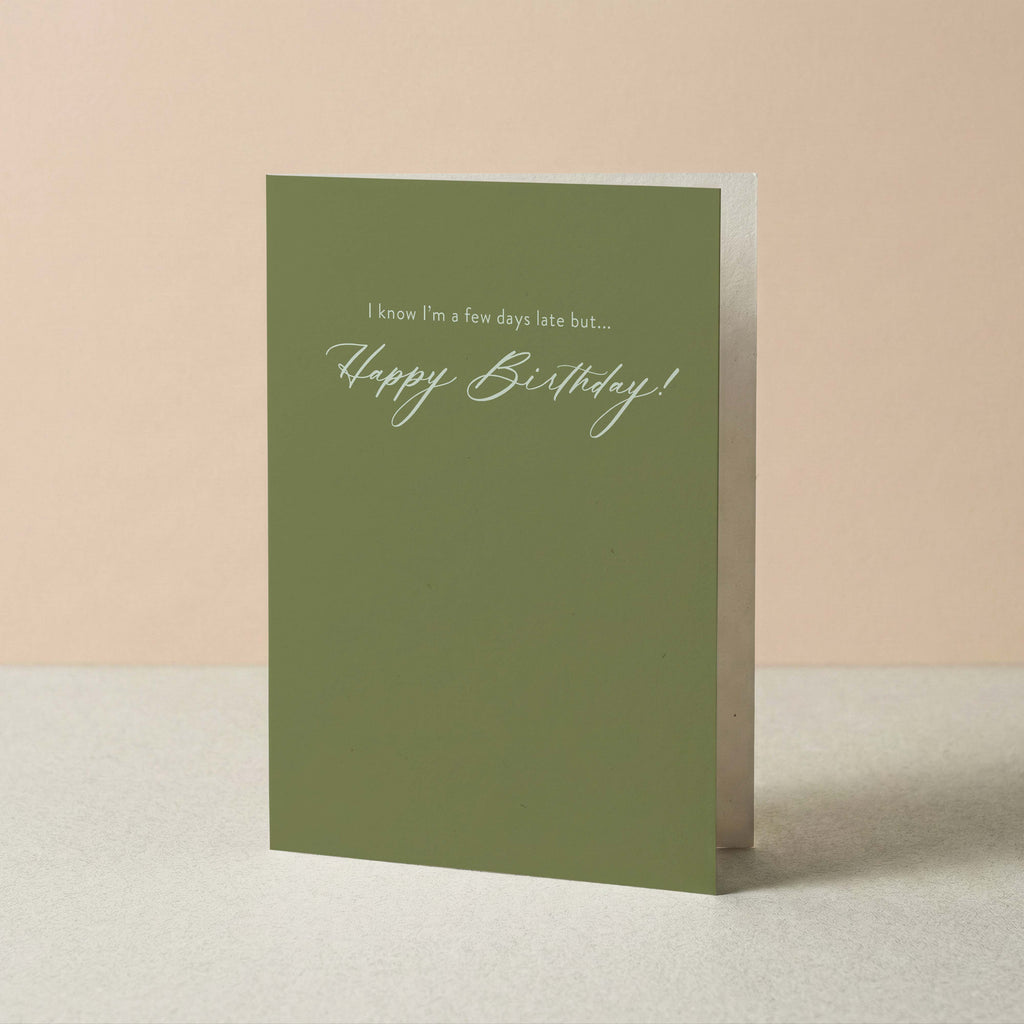 A Few Days Late belated birthday card by Blú Rose standing upright, sage green card with cream script on a neutral background