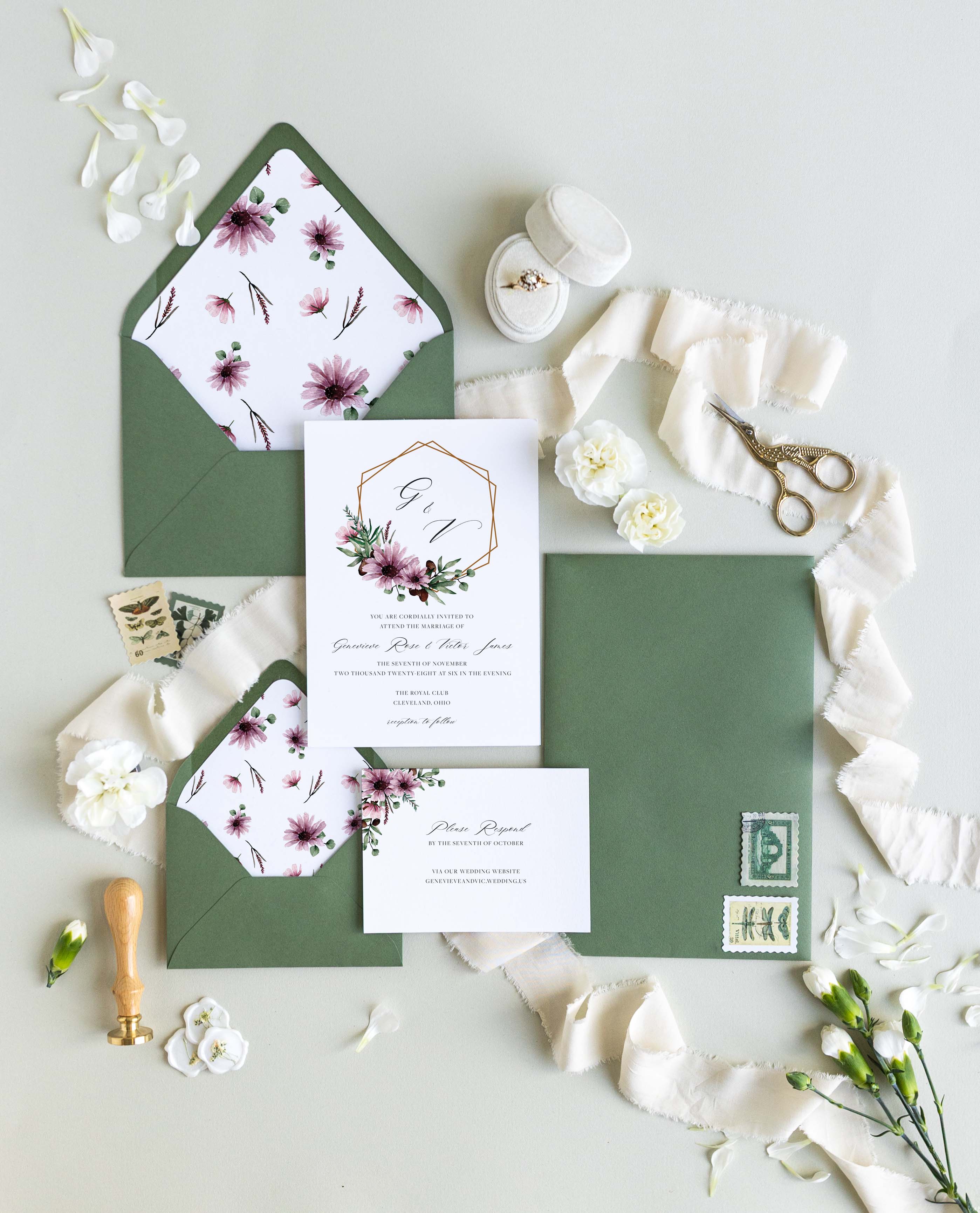 Moody Genevieve wedding invitation suite by Blú Rose, invitation and reply card with a copper geometric frame and mauve florals, styled with sage green envelopes, floral liners, ribbon, and a wax seal