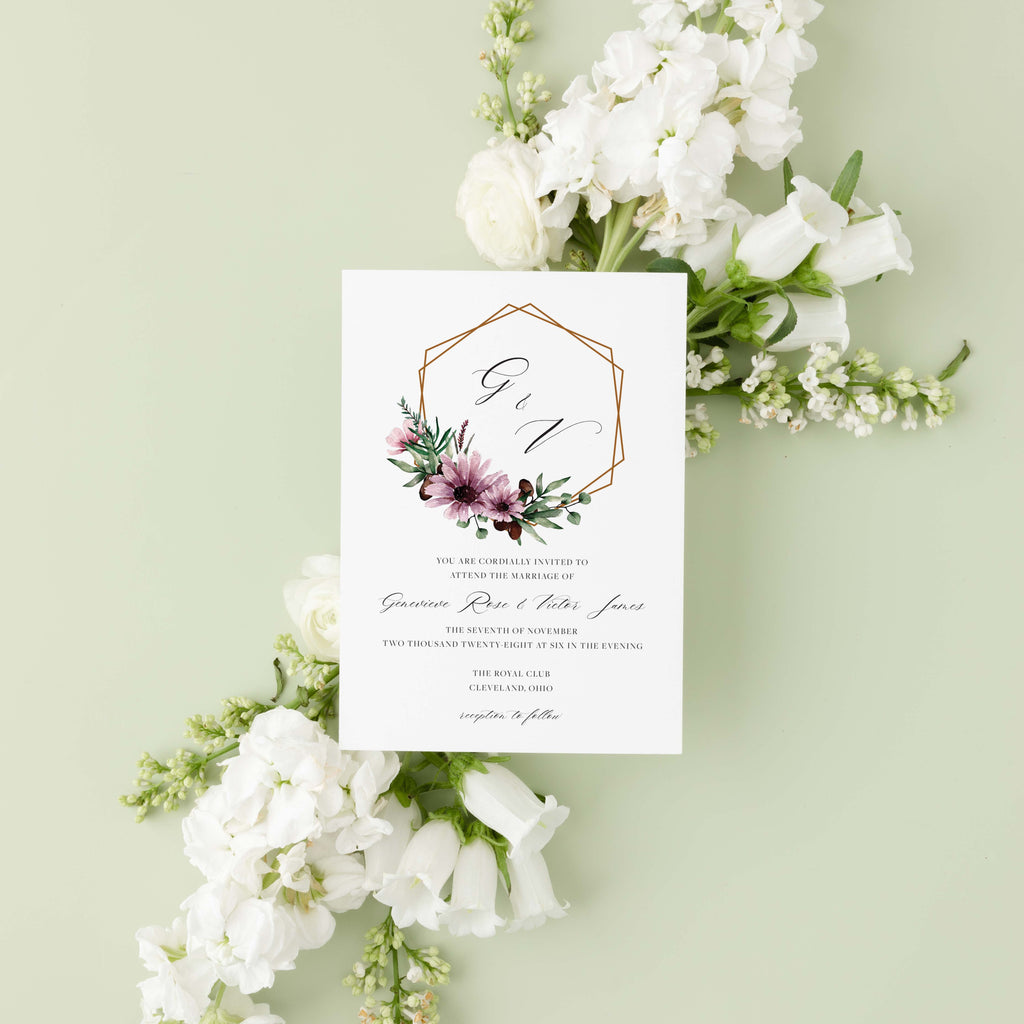 Moody Genevieve wedding invitation by Blú Rose, copper geometric frame with mauve florals and 'G & V' monogram, styled on a sage background with white blooms