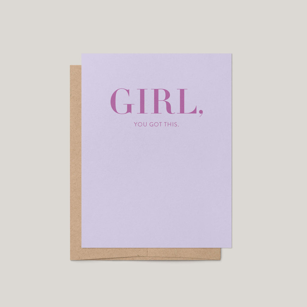 A lavender greeting card with text reading 'GIRL, YOU GOT THIS.' and a kraft paper envelope behind it, shown on a light gray background.
