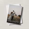 Golden Hour photo holiday card with a full-bleed family photo and MERRY CHRISTMAS in white, on a white envelope