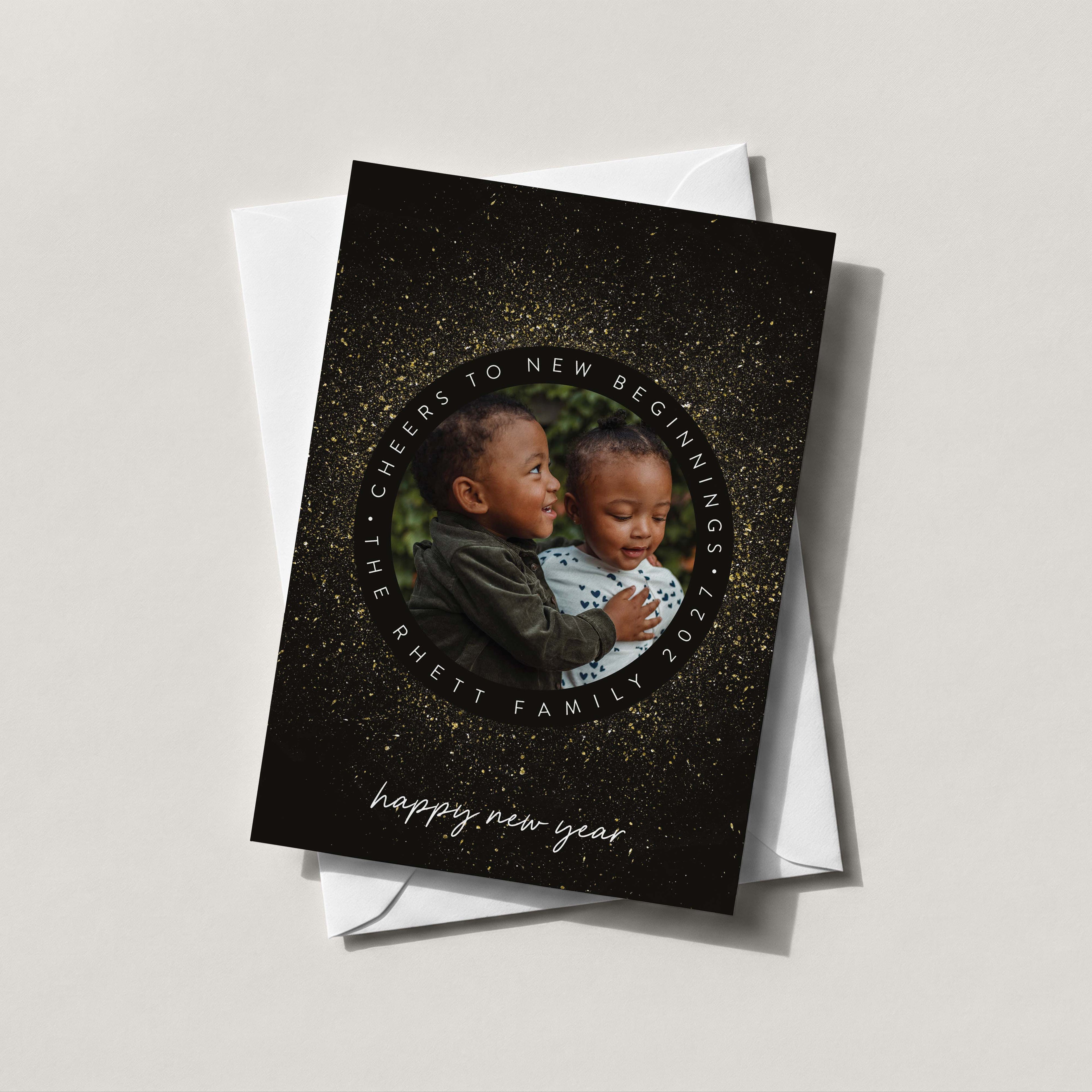 New Year Sparkle photo card in black with a gold starburst wreath framing a baby photo