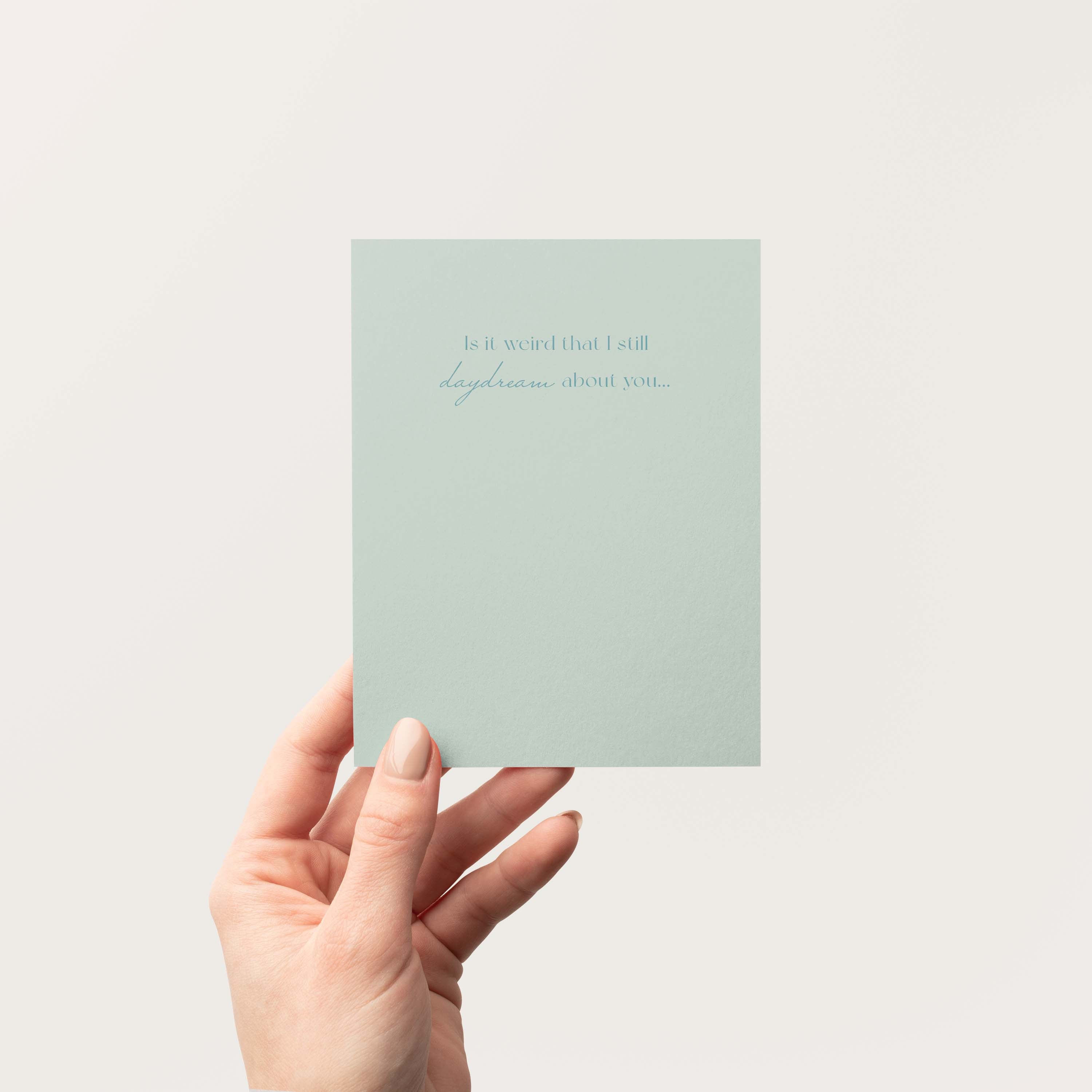 Daydream About You greeting card by Blú Rose held in hand against a neutral off-white background