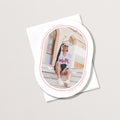 Minimal Geo graduation announcement card with oval photo cutout showing grad sitting on steps, with personalized name and school details