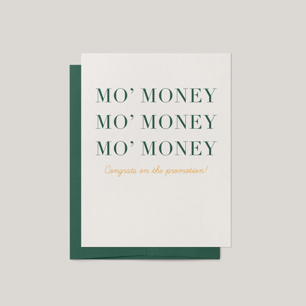 A white greeting card with a dark green envelope behind it, printed with the phrase 'MO' MONEY MO' MONEY MO' MONEY' in dark green serif letters and 'Congrats on the promotion!' in small gold script below, on a light gray background.