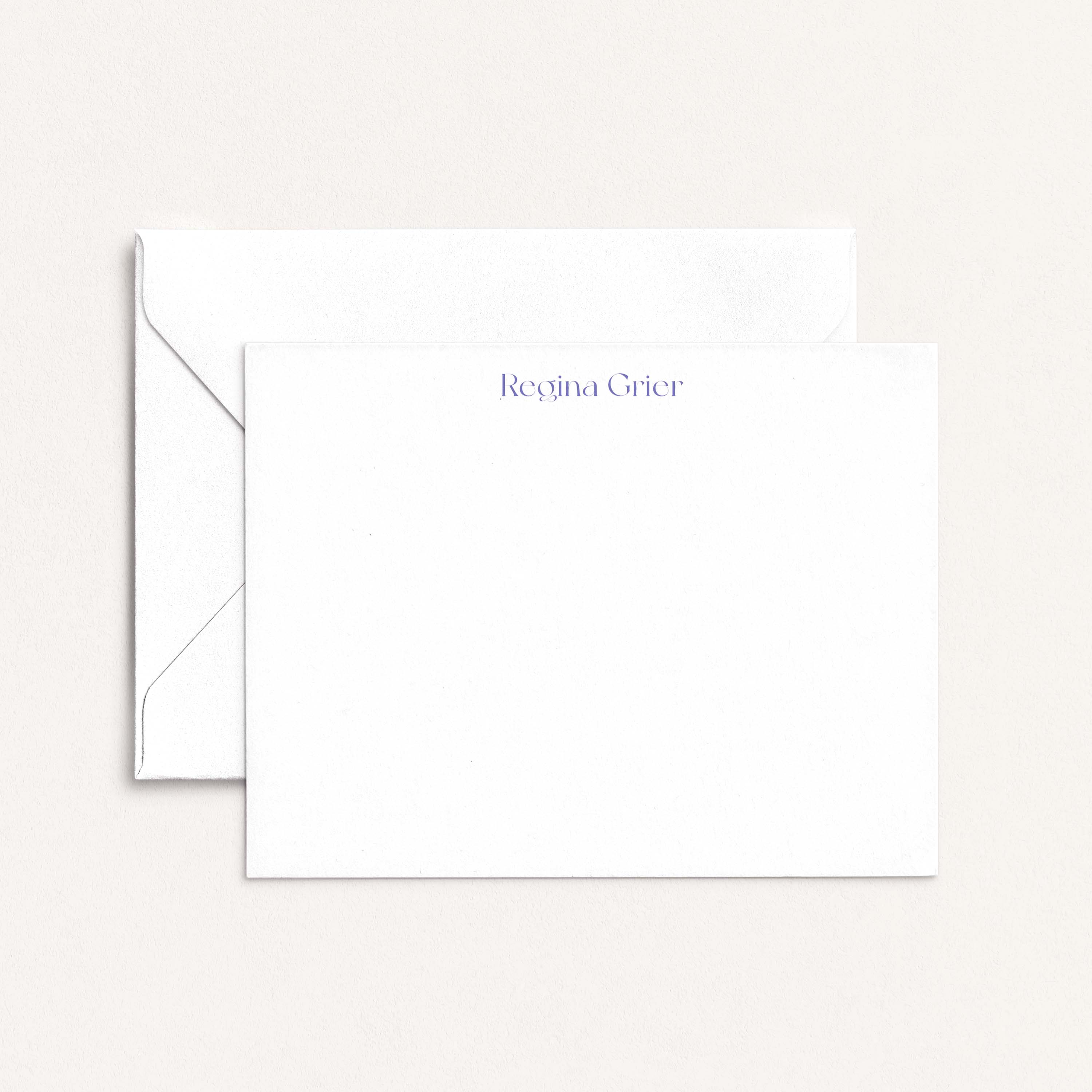 Regina personalized notecards by Blú Rose, white flat notecard with the name 'Regina Grier' in periwinkle, shown with a white envelope