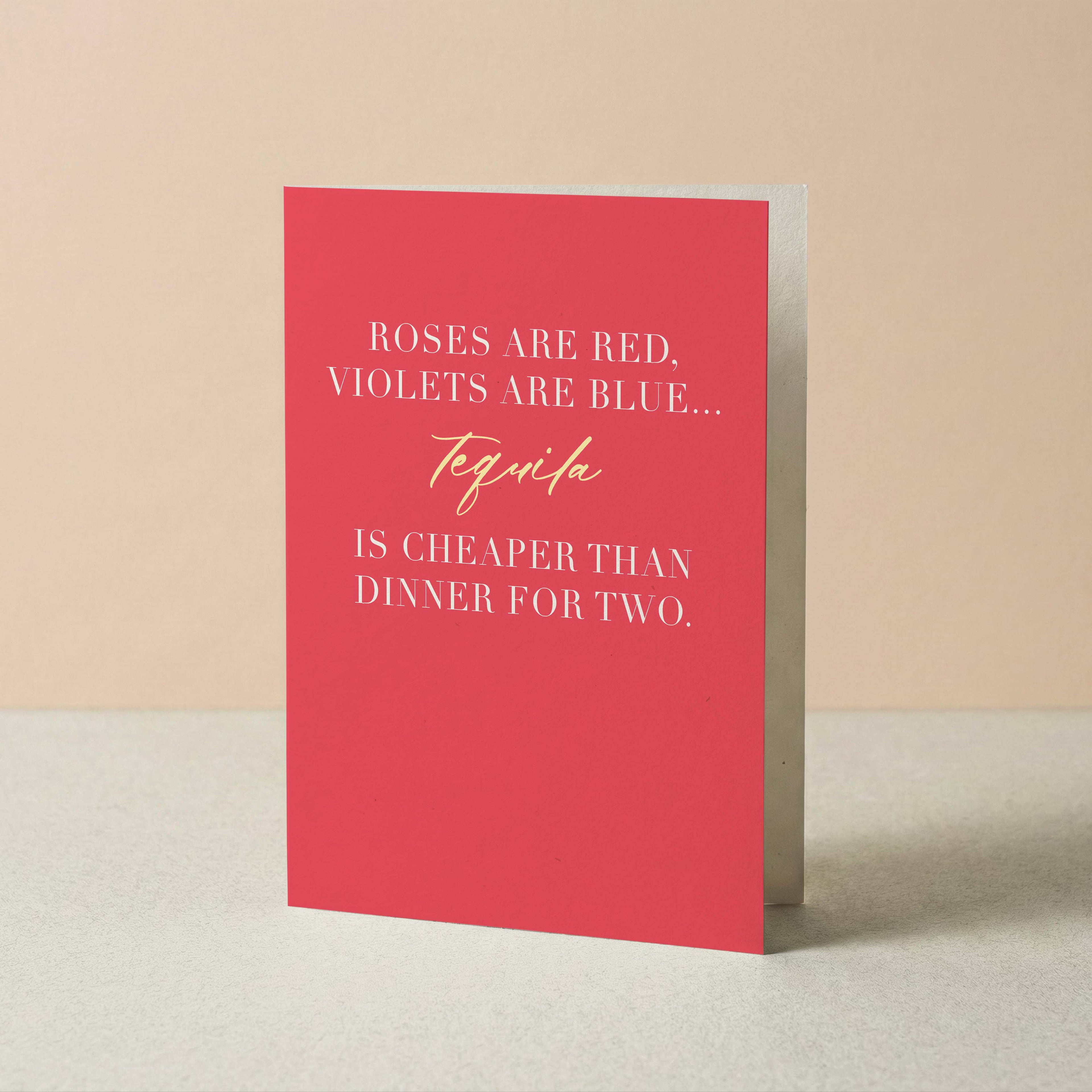 Tequila Is Cheaper Than Dinner funny Valentine's card by Blú Rose standing upright, coral card with roses are red poem on a neutral background