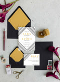 Art Deco wedding invitation suite by Blú Rose, invitation and RSVP card with black diagonal line borders and gold names, styled with gold-lined black envelopes and deep red calla lilies