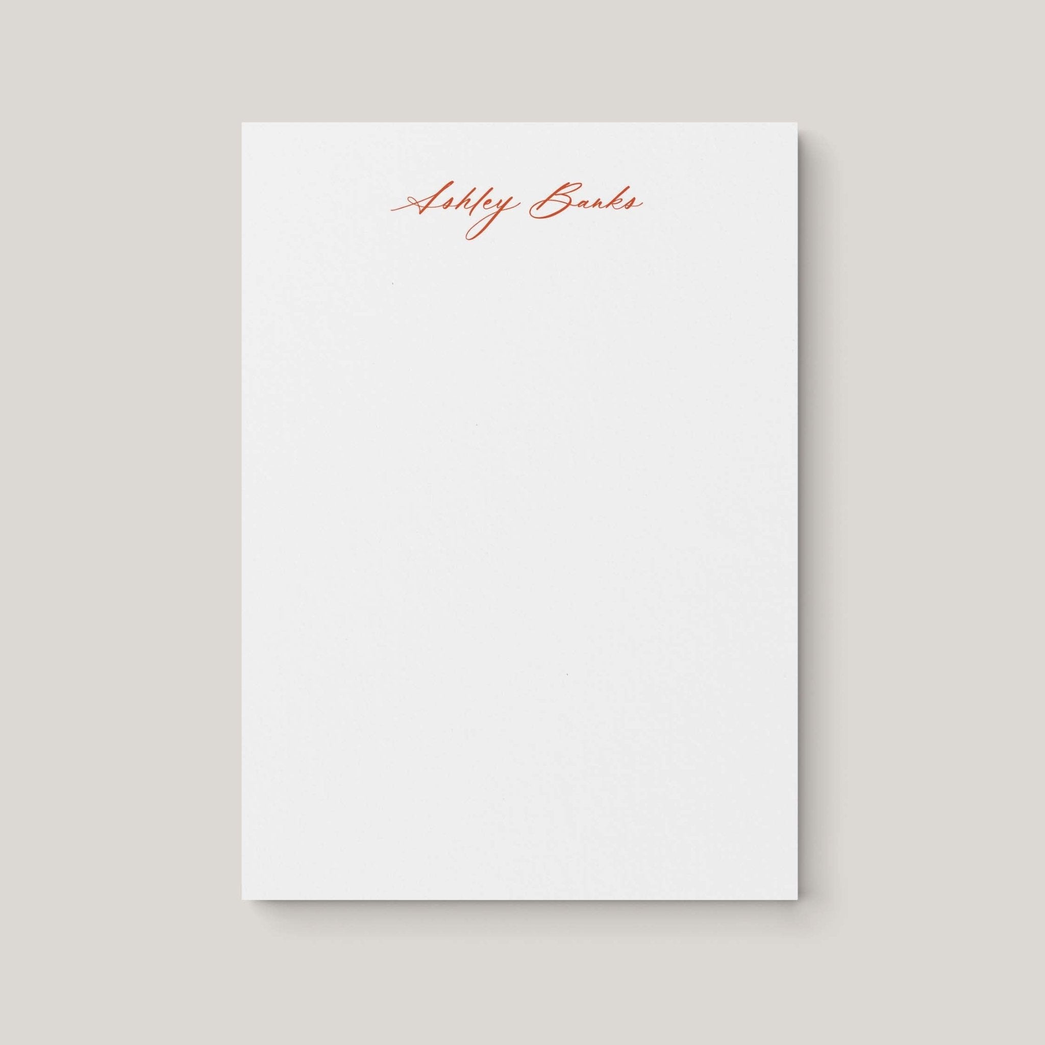 Ashley personalized notepad by Blú Rose, white notepad with the name 'Ashley Banks' in rust cursive script
