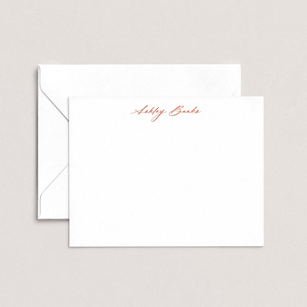 Ashley personalized notecards by Blú Rose, white flat notecard with the name 'Ashley Banks' in rust cursive script, shown with a coordinating white envelope