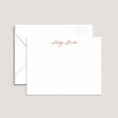 Ashley personalized notecards by Blú Rose, white flat notecard with the name 'Ashley Banks' in rust cursive script, shown with a coordinating white envelope