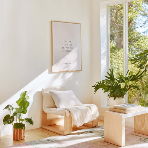 Audre Lorde feminist quote poster styled in bright modern living room with plants and chair
