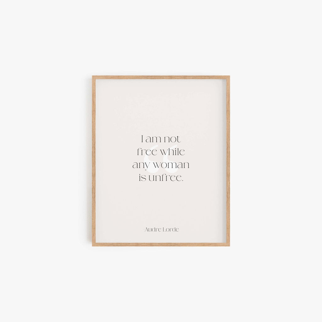 Minimalist Audre Lorde quote art print in light wood frame on neutral wall