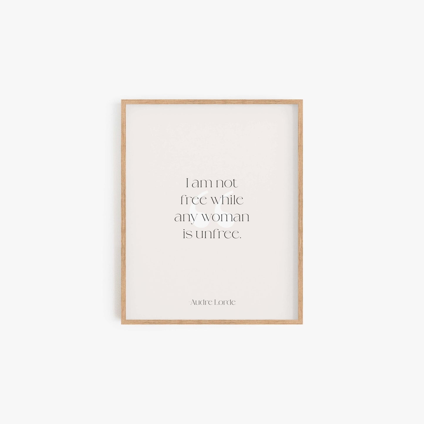 Minimalist Audre Lorde quote art print in light wood frame on neutral wall
