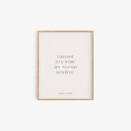 Minimalist Audre Lorde quote art print in light wood frame on neutral wall