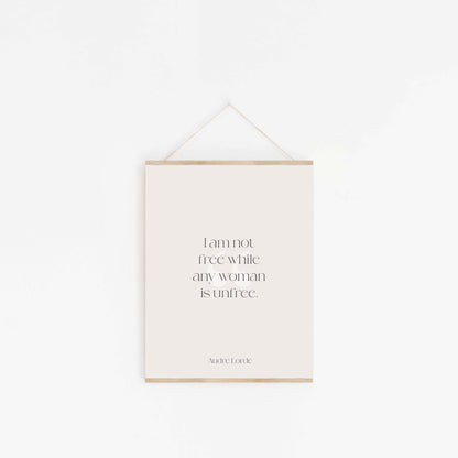 Minimal Audre Lorde quote wall hanging with wood frame and simple cord on white wall