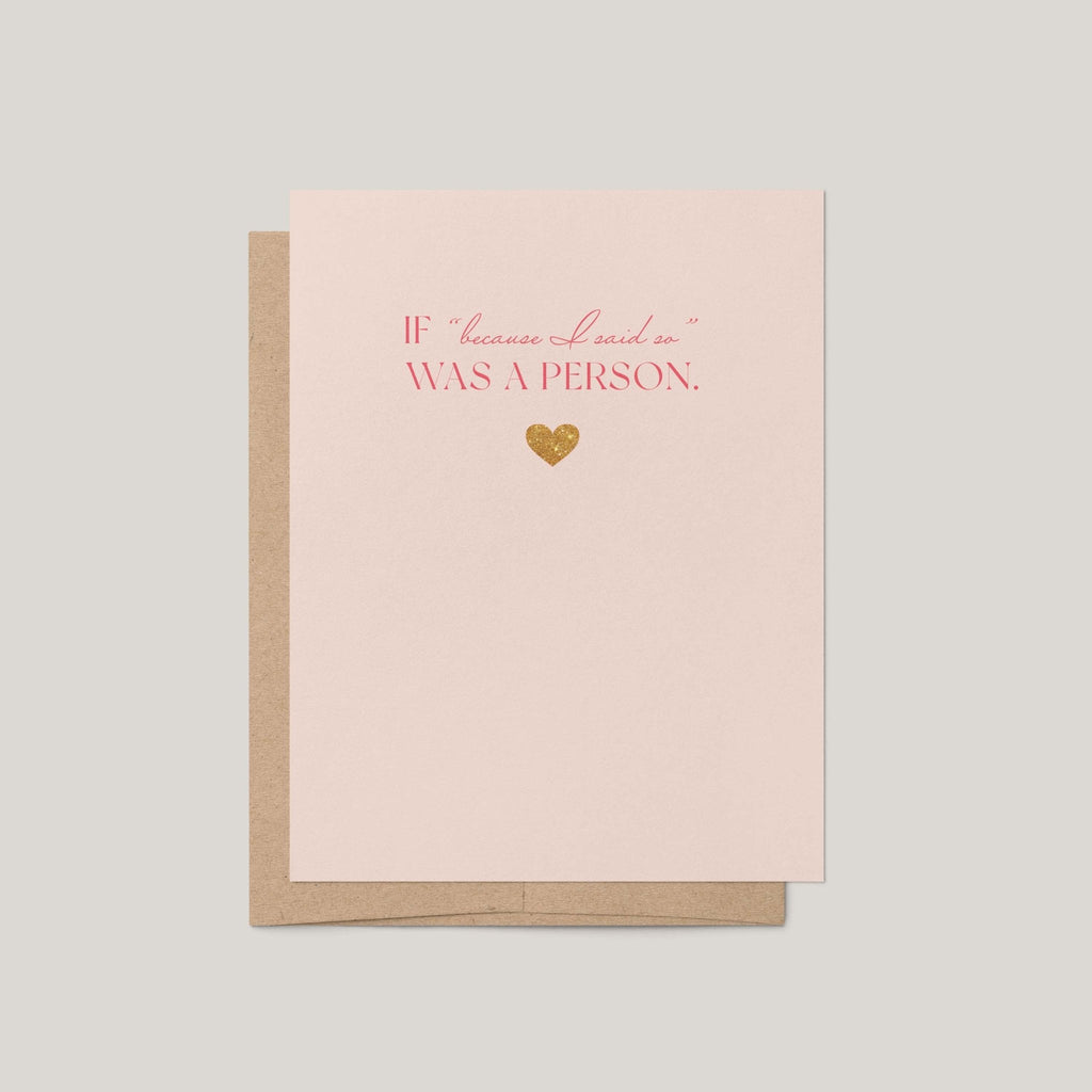 A light blush pink greeting card with a brown kraft envelope behind it, featuring the phrase 'IF "because I said so" WAS A PERSON.' in pink lettering and a small gold foil heart on a neutral gray background.