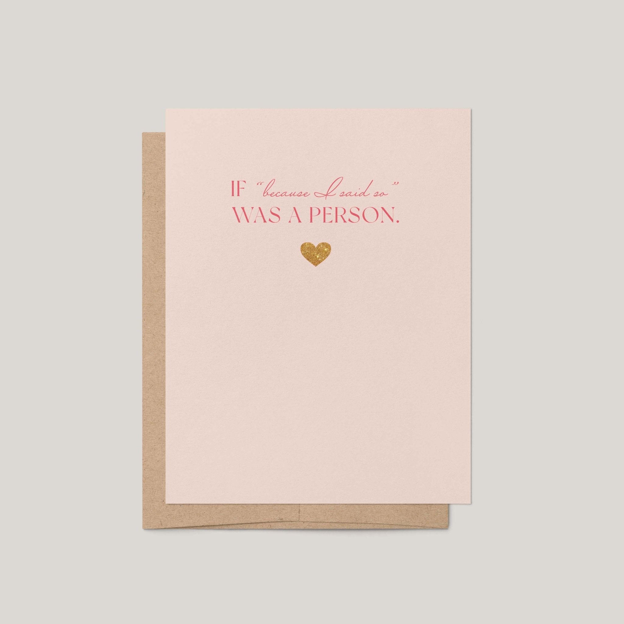 A light blush pink greeting card with a brown kraft envelope behind it, featuring the phrase 'IF "because I said so" WAS A PERSON.' in pink lettering and a small gold foil heart on a neutral gray background.