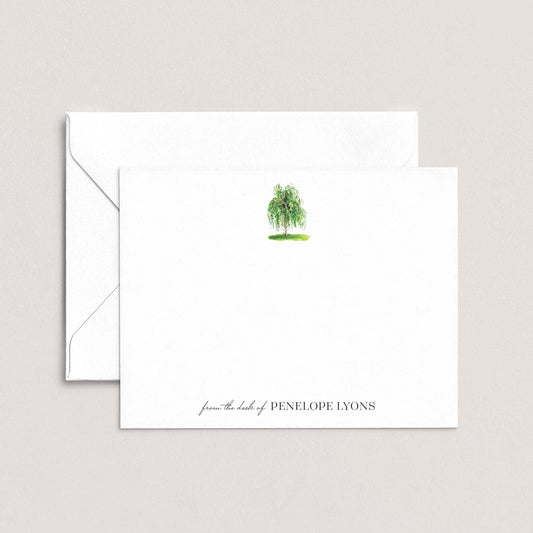 a white envelope with a green tree illustration on the front, and a personalized note on the back.