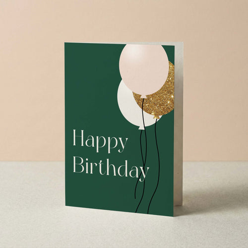 Birthday Balloons card by Blú Rose standing upright, green card with balloon illustration on a neutral background