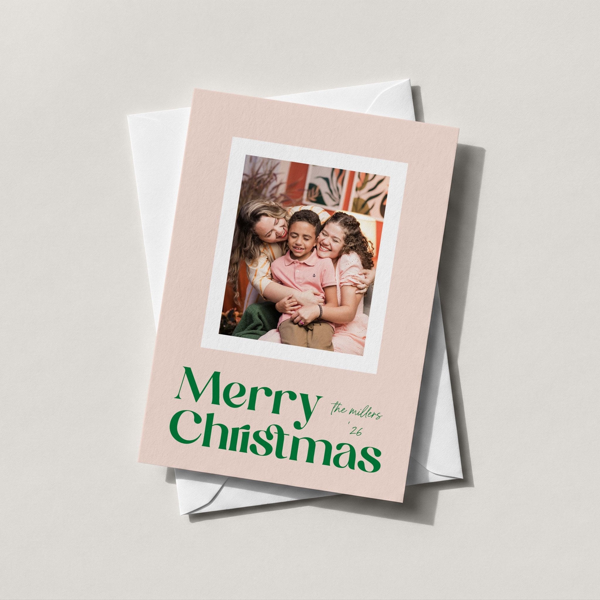 Blush Frame Christmas photo card with a family photo and Merry Christmas in green script