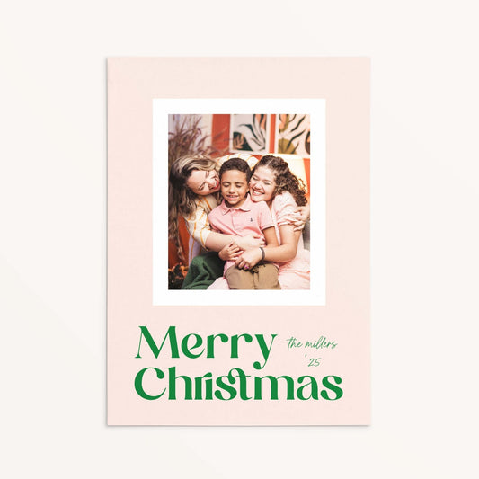 Blush Frame Merry Christmas photo card with modern green serif font and family photo in white border.