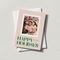 Blush Frame photo holiday card with a family photo and HAPPY HOLIDAYS in green block lettering