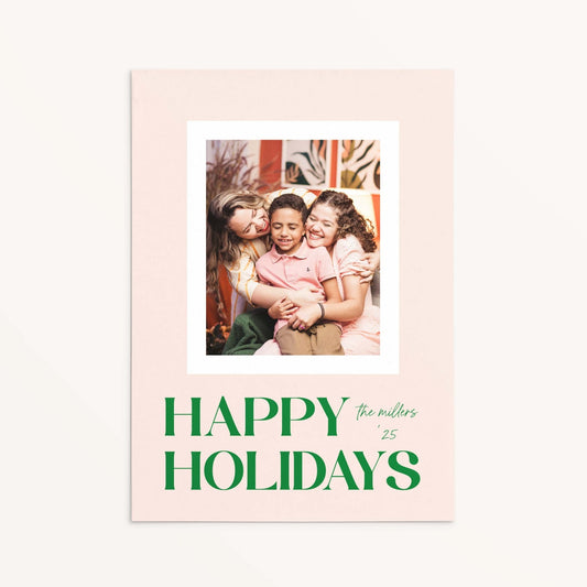 Blush Frame Happy Holidays photo card featuring family photo with bold green serif lettering.