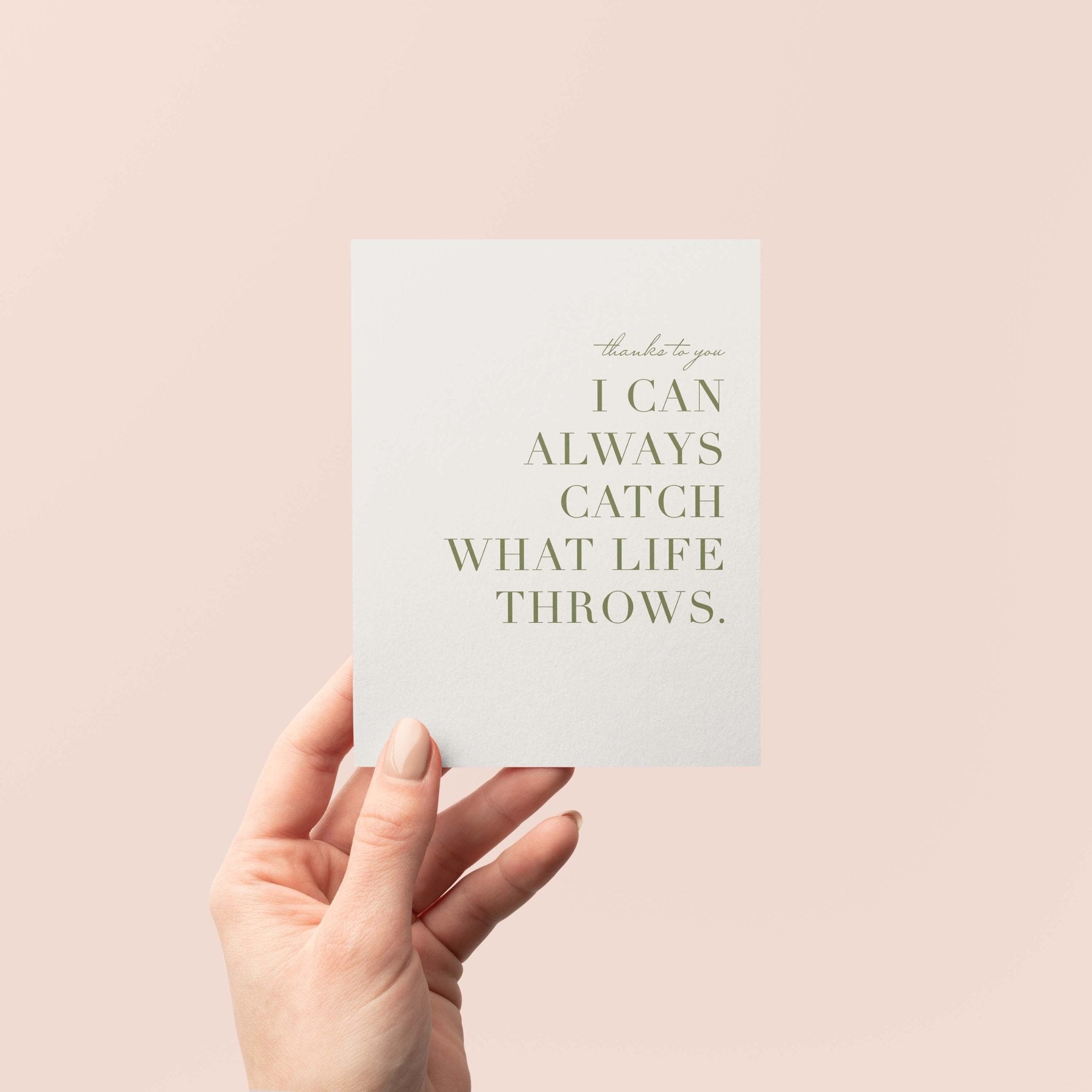 Catch What Life Throws greeting card by Blú Rose held in hand against a neutral off-white background