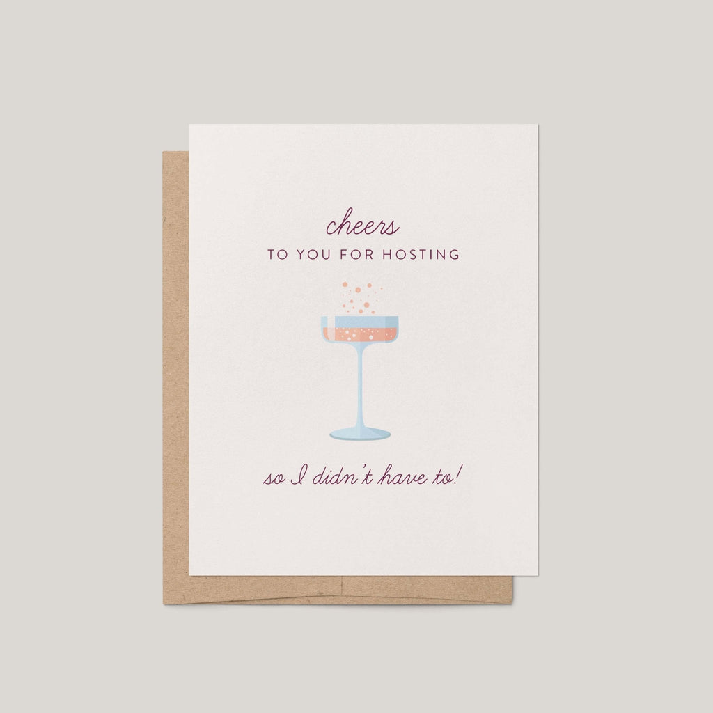 Cheers to Hosting greeting card by Blú Rose, ivory card with mauve script and champagne coupe illustration, shown with kraft envelope