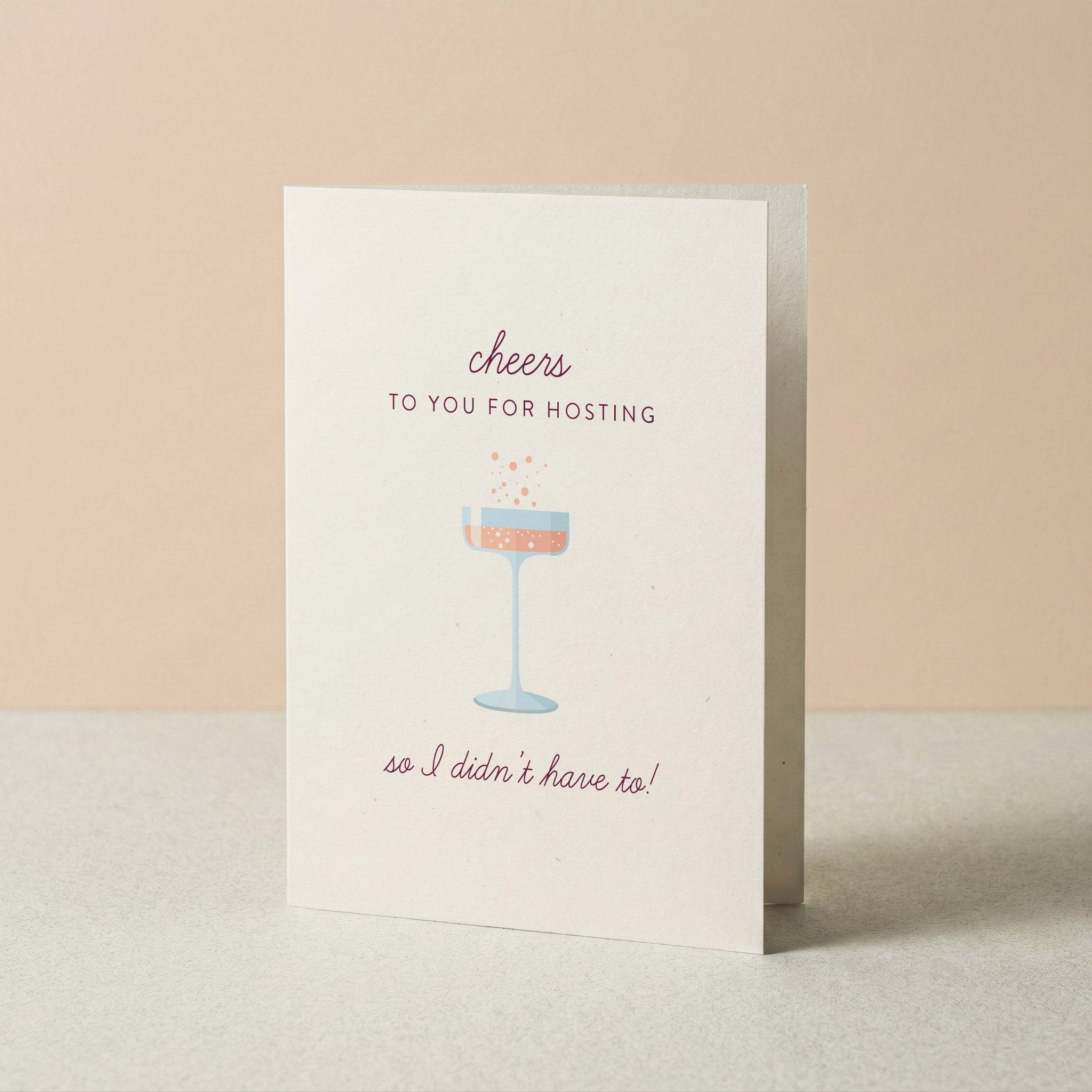Cheers to Hosting hostess thank you card by Blú Rose standing upright, ivory card with champagne coupe illustration on a neutral background
