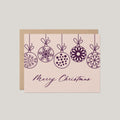 Christmas Ornaments holiday greeting card by Blú Rose, blush card with plum line-drawn hanging ornaments and Merry Christmas script, shown with kraft envelope