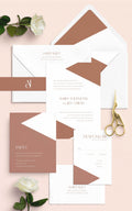 Classy Geo wedding invitation suite by Blú Rose, invitation with terracotta geometric color blocks plus reply and party cards, styled on blush with terracotta-lined envelopes, roses, and gold scissors