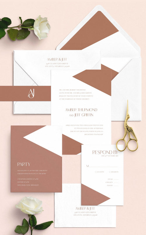 Classy Geo wedding invitation suite by Blú Rose, invitation with terracotta geometric color blocks plus reply and party cards, styled on blush with terracotta-lined envelopes, roses, and gold scissors